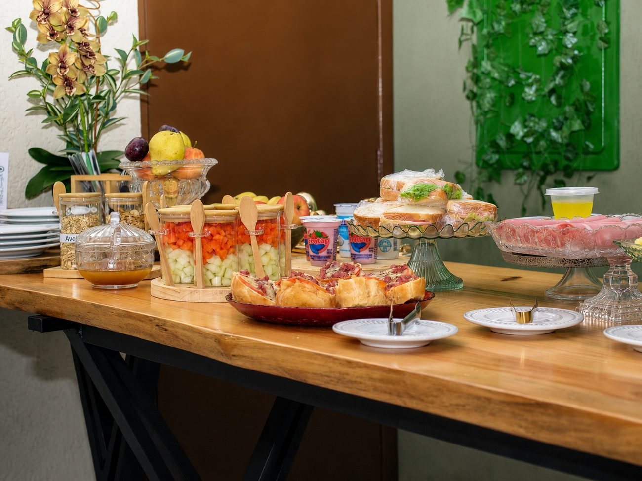 Mesa servida com sanduíches, frios e frutas