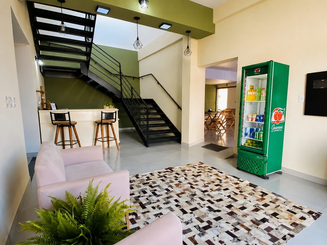 Recepção com escada e geladeira de bebidas